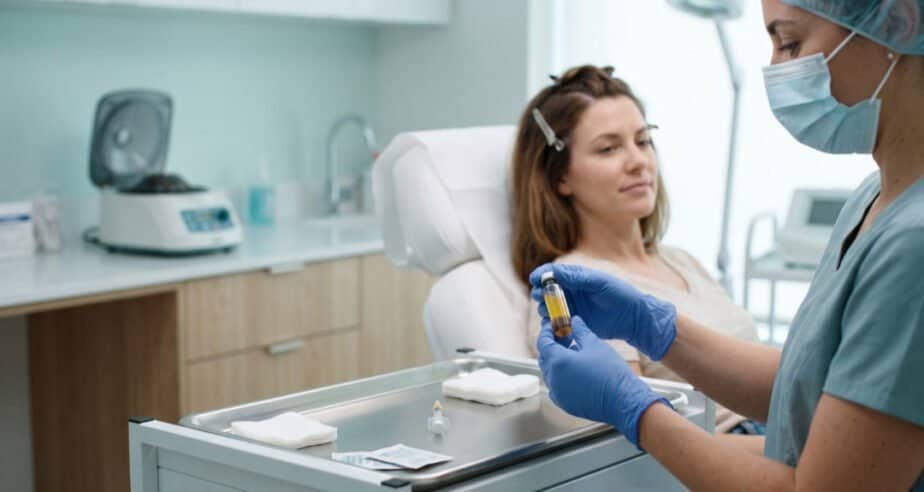 Doctor holding a vial of platelet-rich plasma before a PRP hair treatment session for thinning hair